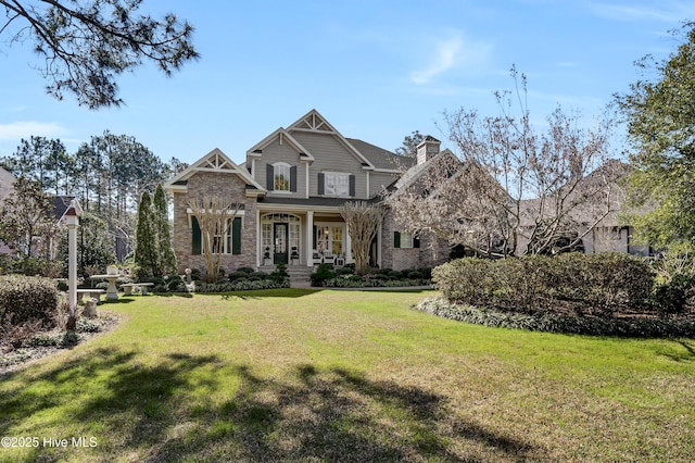 craftsman inspired home with a front yard and a chimney