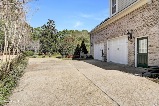 view of side of home with concrete driveway and brick siding