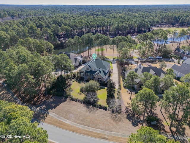 aerial view of property's location featuring a forest and a large body of water