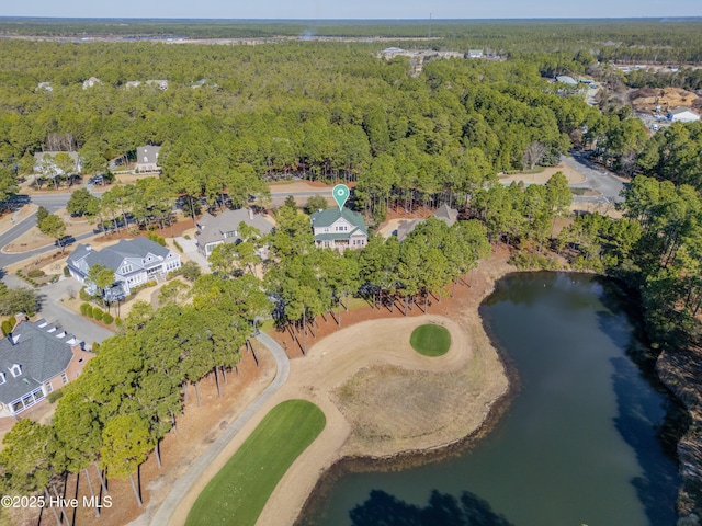 drone / aerial view with a water view, view of golf course, and a view of trees