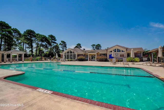 community pool with a gazebo, a patio, and fence