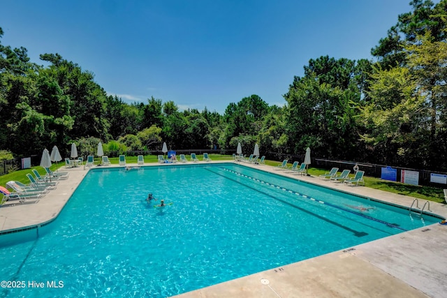 community pool with fence and a patio area