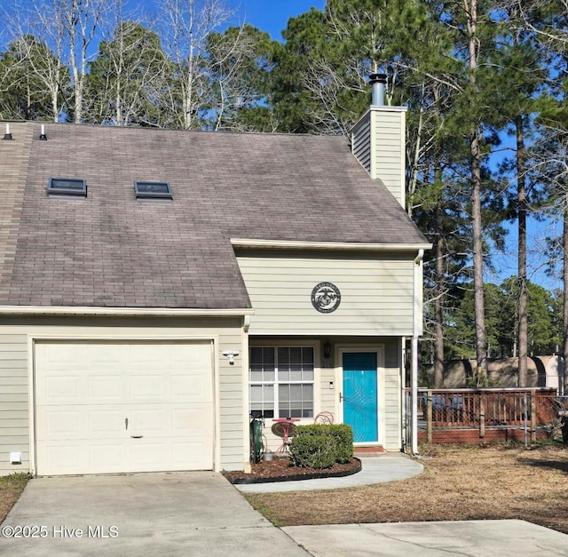 multi unit property with a garage, concrete driveway, a chimney, and roof with shingles