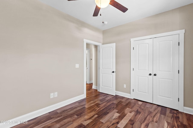 unfurnished bedroom featuring dark wood-style floors, a closet, ceiling fan, and baseboards