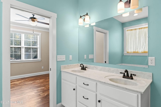 bathroom featuring double vanity, crown molding, baseboards, and a sink