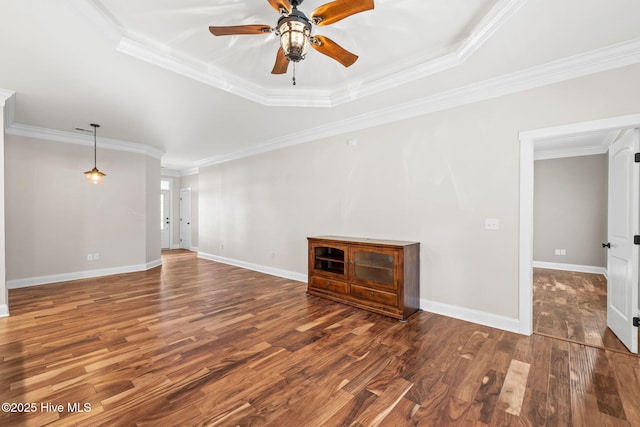 unfurnished living room with dark wood-style floors, baseboards, ornamental molding, and a ceiling fan