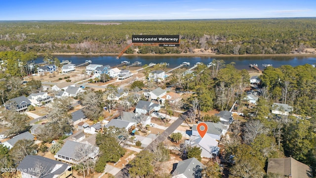 drone / aerial view with a water view and a forest view