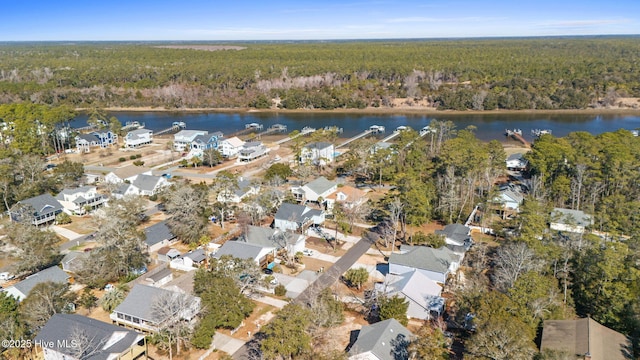 aerial view with a water view and a wooded view