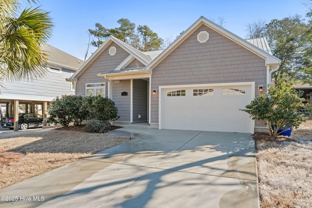 view of front of property with metal roof, driveway, and an attached garage