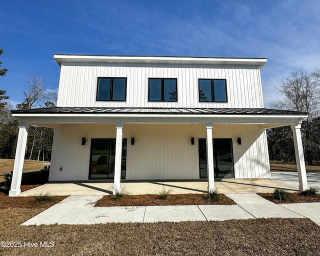 back of house featuring metal roof, a patio, and a standing seam roof