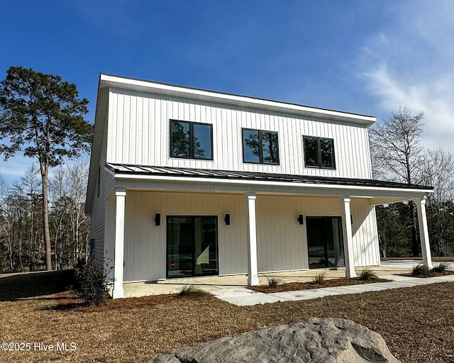 rear view of house with metal roof and a standing seam roof