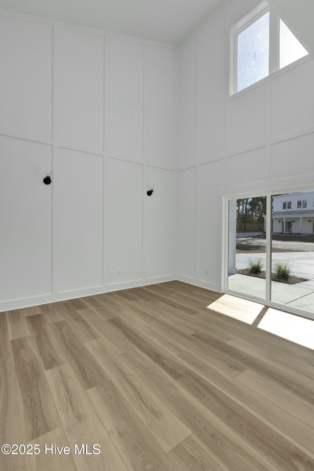 spare room featuring light wood-style flooring and a decorative wall