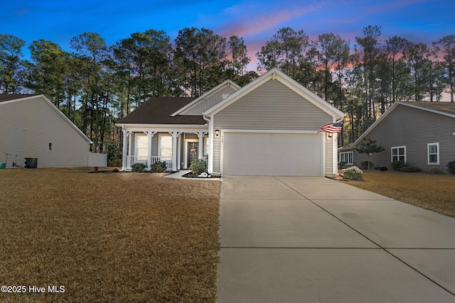 single story home with a porch, board and batten siding, a garage, driveway, and a front lawn