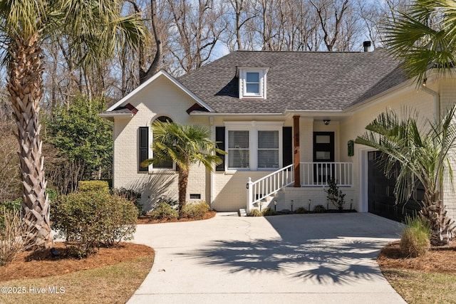 view of front of property featuring brick siding, driveway, and a shingled roof