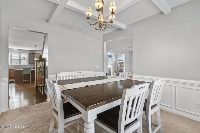 128 Pamlico Dr, Holly Ridge, NC 28445 - dining area featuring a wainscoted wall, carpet floors, beamed ceiling, and a notable chandelier