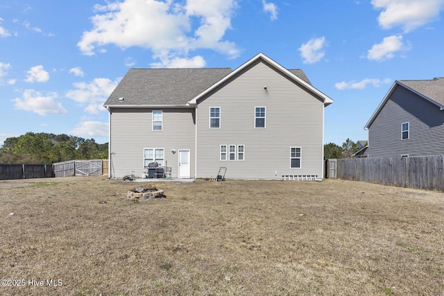 128 Pamlico Dr, Holly Ridge, NC 28445 - back of house featuring a fenced backyard, a lawn, a fire pit, and roof with shingles