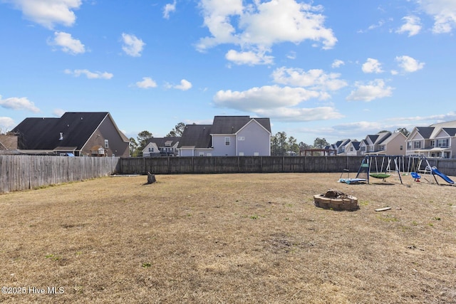 128 Pamlico Dr, Holly Ridge, NC 28445 - view of yard featuring an outdoor fire pit, a playground, a fenced backyard, and a residential view