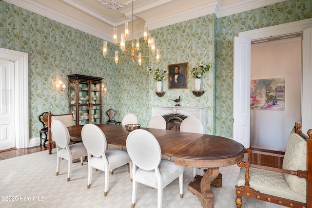 dining space with ornamental molding, wood finished floors, and wallpapered walls