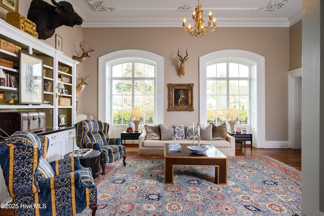 sitting room with ornamental molding, a chandelier, and wood finished floors