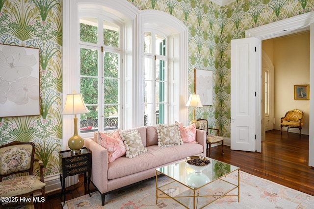 living area featuring dark wood-type flooring, baseboards, and wallpapered walls