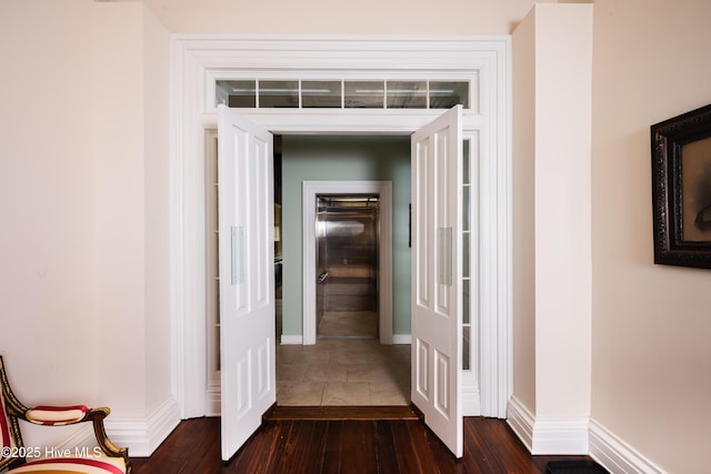 hall featuring dark wood-style floors and baseboards