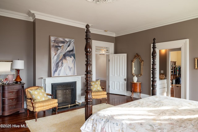 bedroom with ornamental molding, dark wood-style flooring, a fireplace with flush hearth, and baseboards