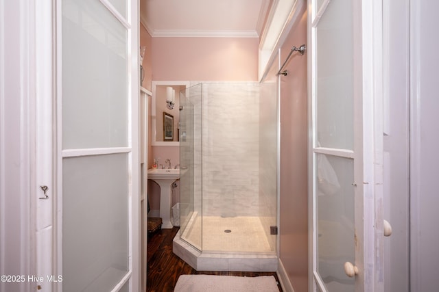 bathroom with a sink, a shower stall, and crown molding