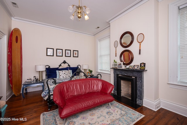 bedroom featuring ornamental molding, dark wood-style flooring, a chandelier, and a fireplace