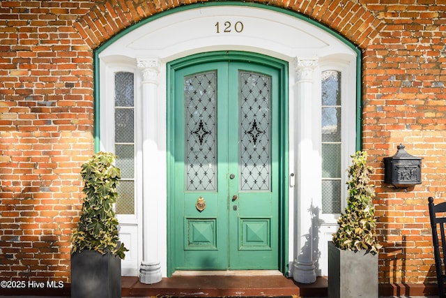 doorway to property featuring brick siding