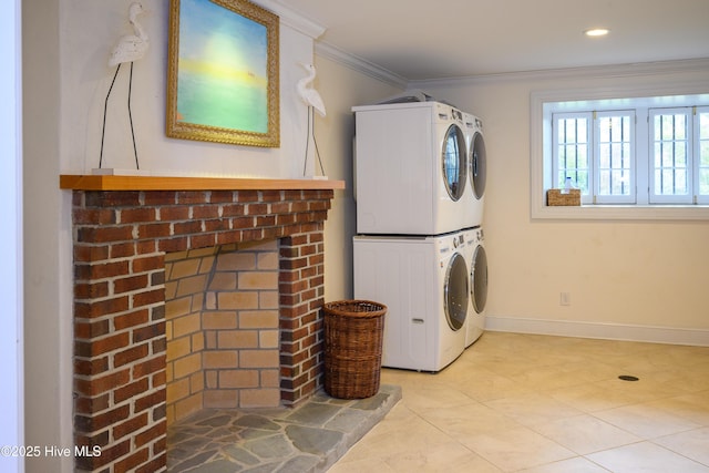 washroom featuring stacked washer / drying machine, ornamental molding, a brick fireplace, laundry area, and baseboards