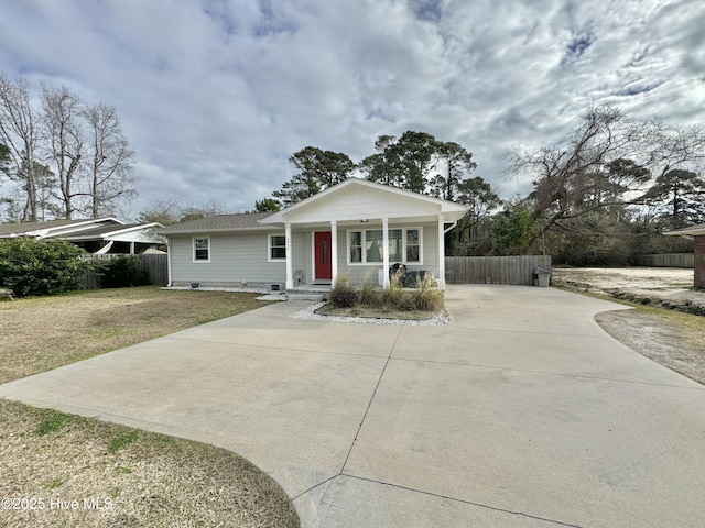 view of front of home featuring driveway, crawl space, covered porch, fence, and a front yard