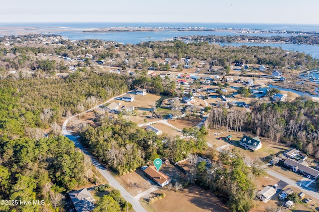 aerial view with a water view and a wooded view