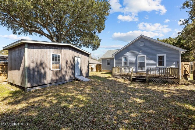 deck featuring an outdoor structure and a fenced backyard