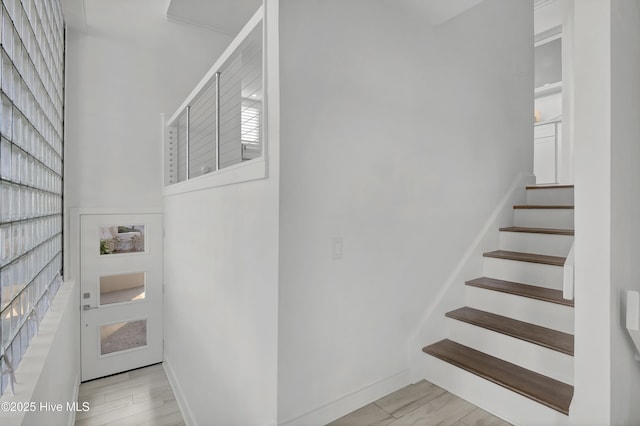 stairs with wood finished floors and baseboards