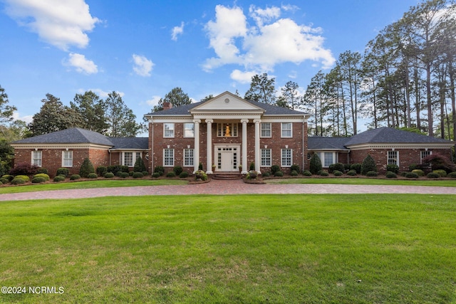 neoclassical / greek revival house with brick siding and a front lawn