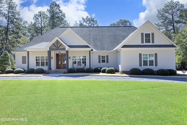 view of front of property with roof with shingles, french doors, and a front yard