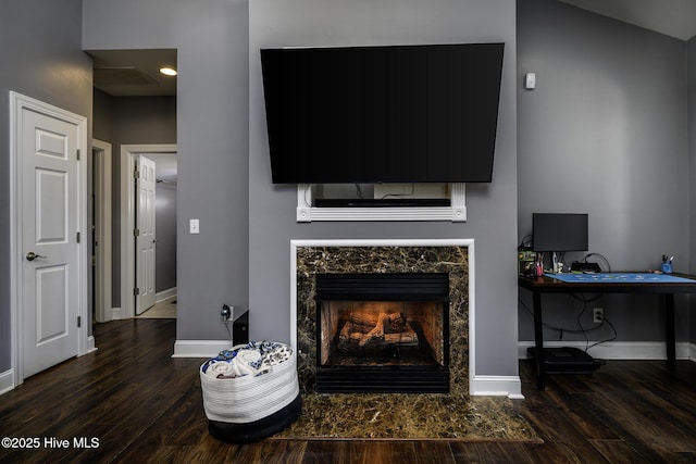 living room with baseboards, wood finished floors, and a high end fireplace