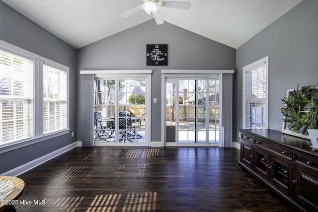 interior space featuring lofted ceiling, ceiling fan, baseboards, and wood finished floors