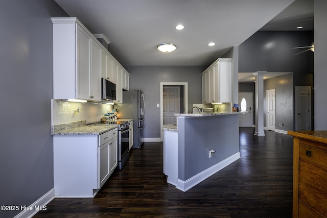 kitchen featuring stainless steel appliances, tasteful backsplash, white cabinets, and ornate columns