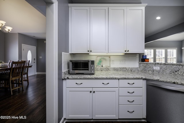 kitchen featuring dark wood-style flooring, a toaster, decorative backsplash, stainless steel dishwasher, and white cabinets