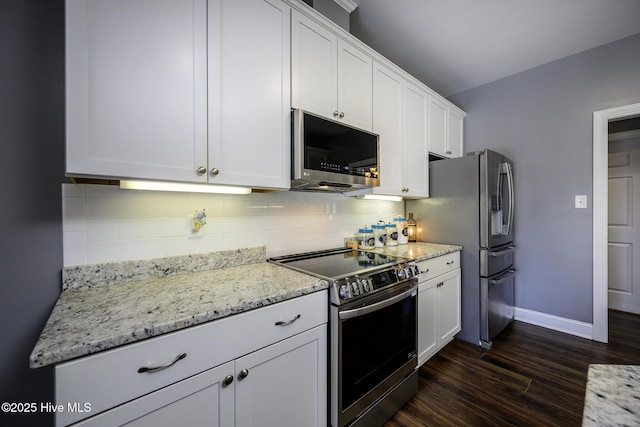 kitchen with baseboards, dark wood-type flooring, stainless steel appliances, white cabinetry, and backsplash