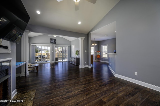 unfurnished living room featuring vaulted ceiling, ceiling fan, ornate columns, and wood finished floors