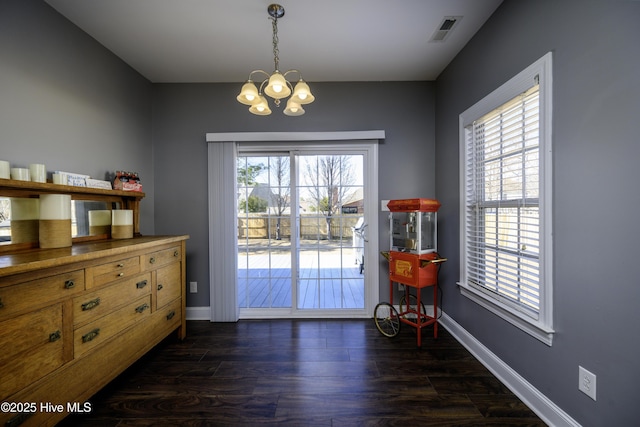 doorway with dark wood-type flooring, a wealth of natural light, visible vents, and baseboards