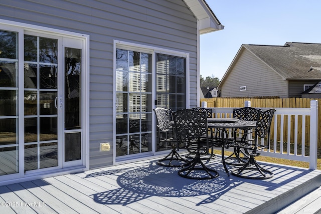 wooden deck with outdoor dining area and fence