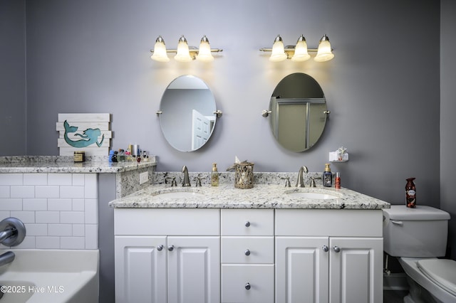 full bathroom featuring a bathing tub, a sink, toilet, and double vanity