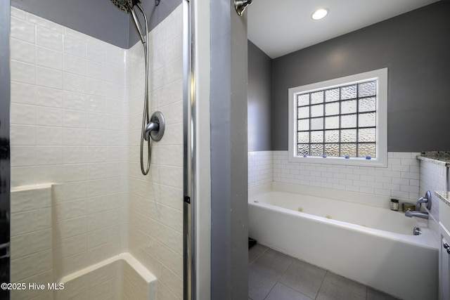 bathroom featuring a stall shower, tile patterned flooring, and a bath