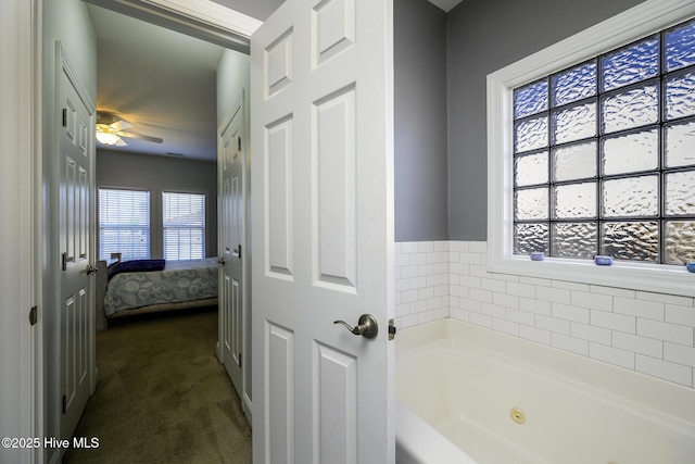 bathroom with ceiling fan and a tub with jets