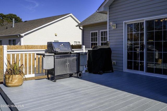 wooden terrace featuring area for grilling and fence