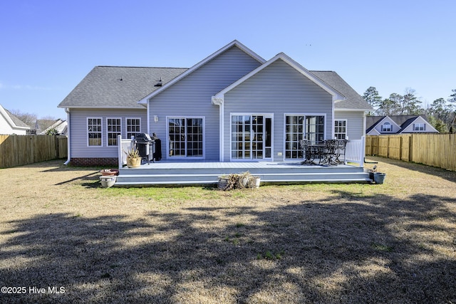 back of property featuring a shingled roof, a fenced backyard, a yard, and a wooden deck