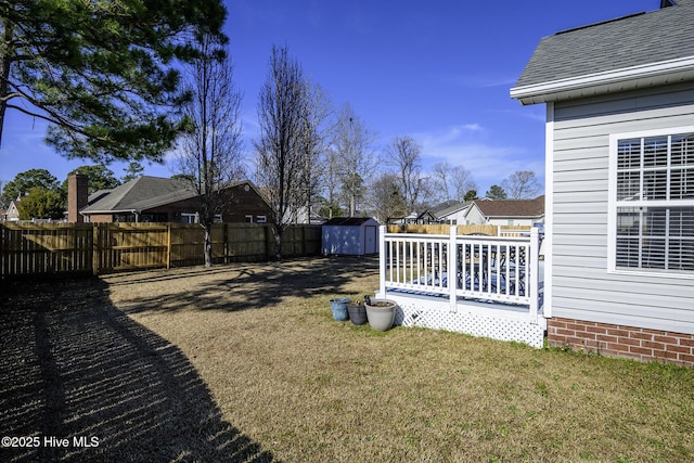 view of yard featuring a shed, a fenced backyard, and an outdoor structure